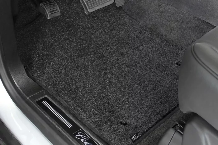 A black carpet mat installed on a vehicle’s floor